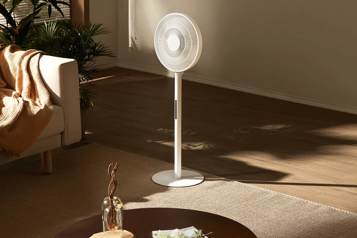 Woonkamer met de Xiaomi Mijia Smart Standing Fan Pro Slim en een salontafel in het zonlicht
