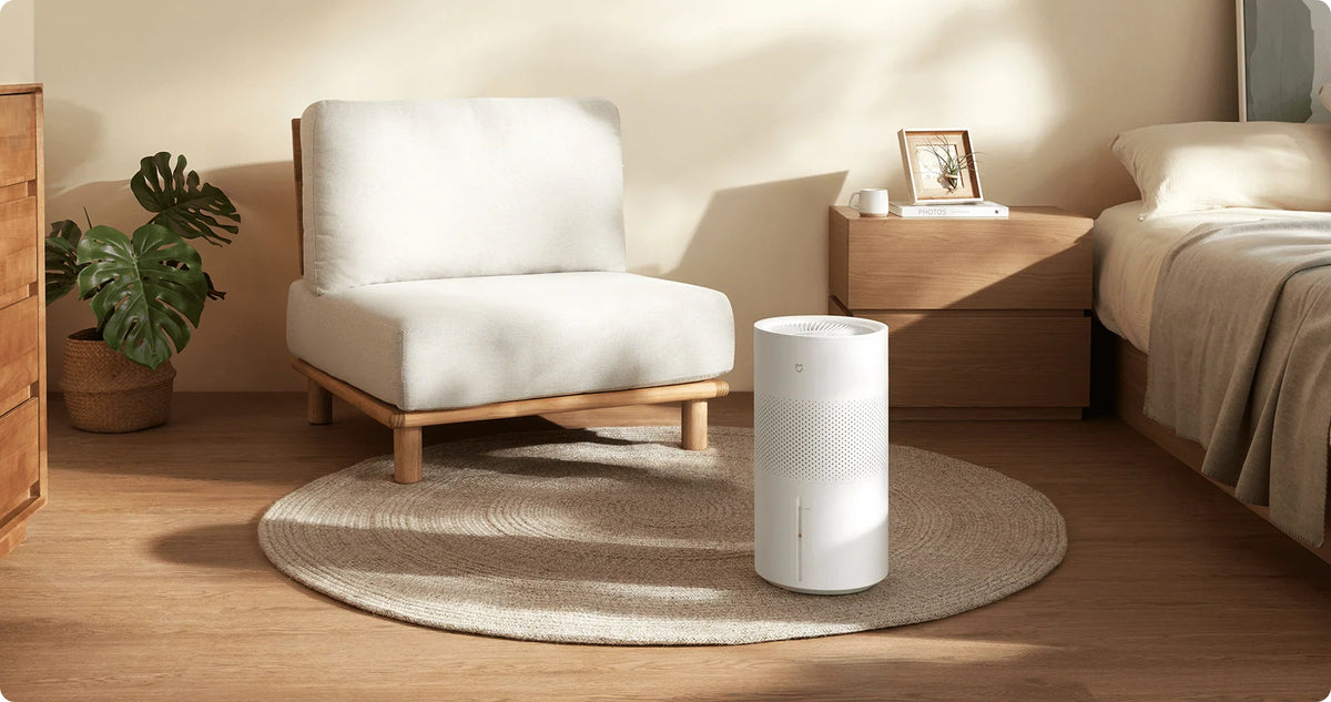 Xiaomi Smart Evaporative Humidifier Pro op een rond vloerkleed naast een fauteuil
