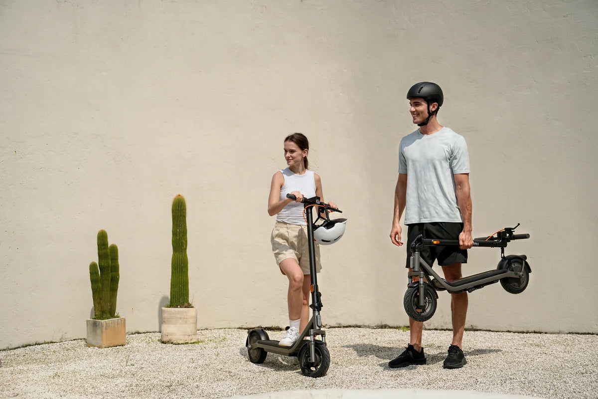 Opgevouwen Xiaomi Electric Scooter 6 Lite onder de arm meenemen naar binnen