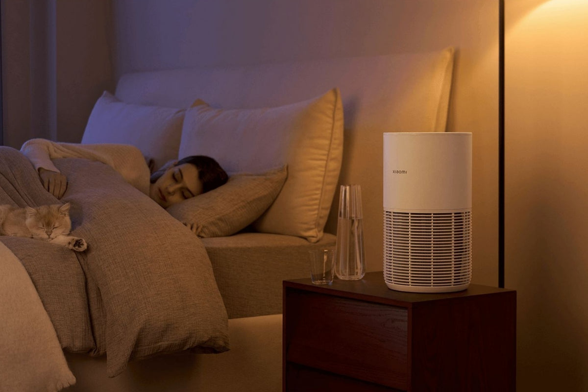 Vrouw en kat slapend in bed met Xiaomi luchtreiniger op nachtkasten