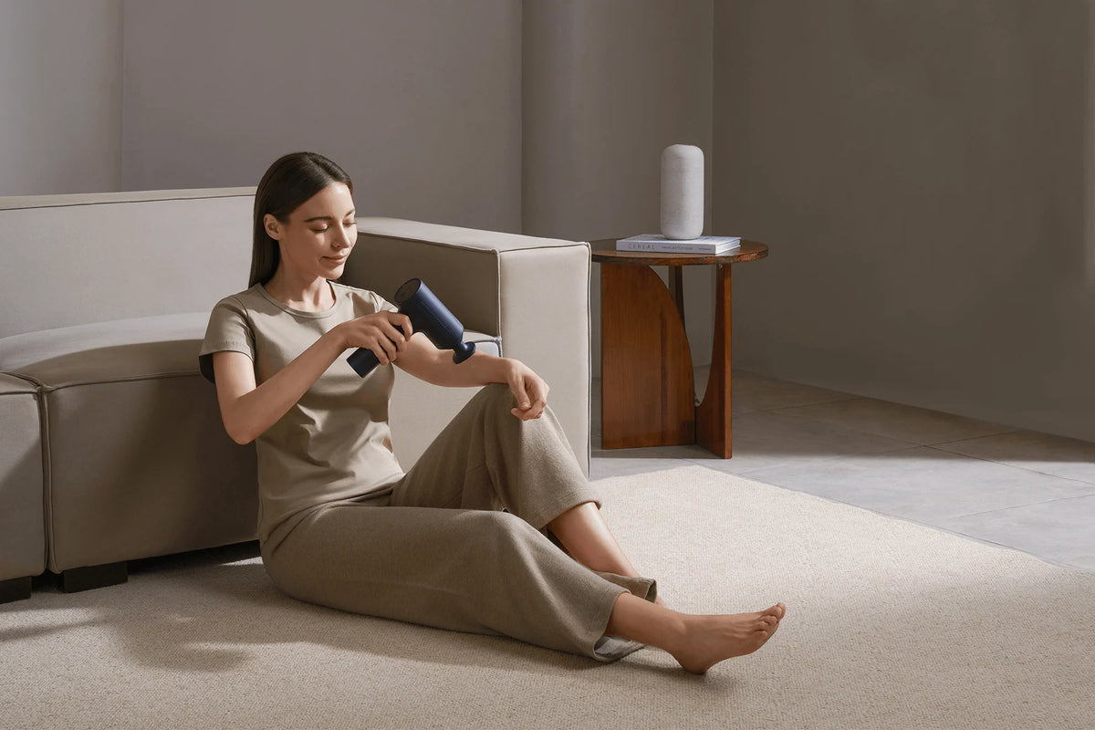 Xiaomi Massage Gun 2 in gebruik op het bovenbeen, zittend op de vloer
